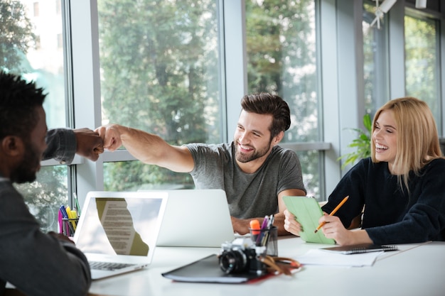 젊은 동료 사무실 coworking에 앉아 웃 고