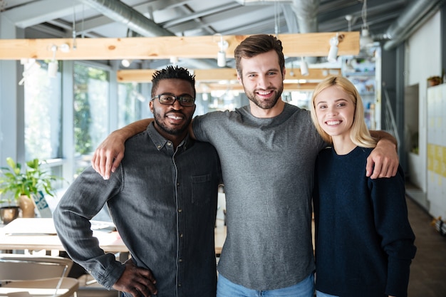 Smiling young colleagues standing in office