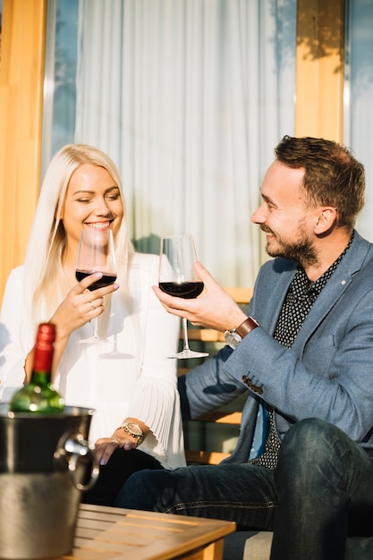 Free photo smiling young couple enjoying drinks together