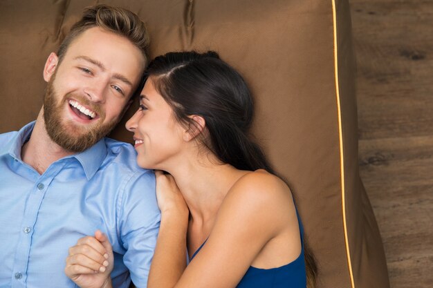 Smiling young couple enjoying lying on sofa