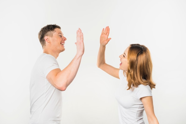 Smiling young couple giving high five to each other isolated on white background