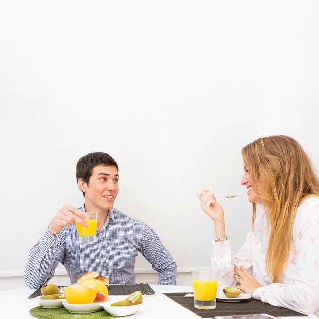 健康的な朝食を持つ若いカップルに笑顔