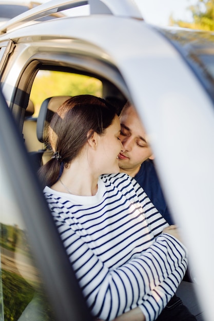 Foto gratuita sorridente giovane coppia all'interno di un'auto. baciare in macchina