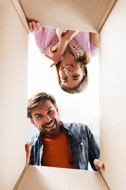 Smiling young couple looking into the cardboard box