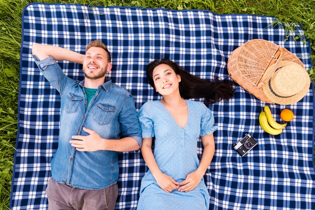 Smiling young couple lying on grass