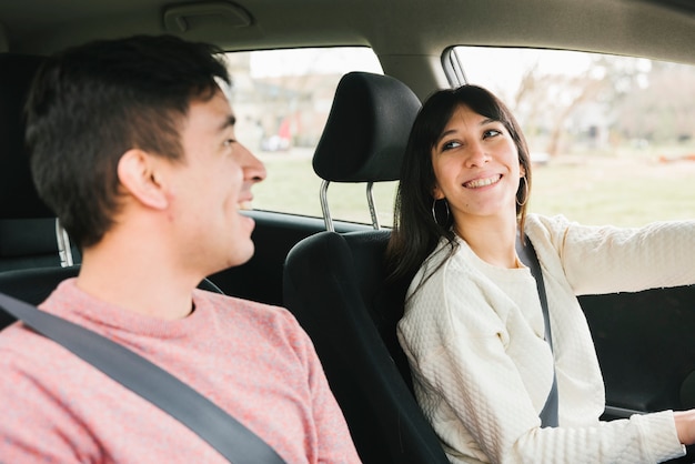 Smiling young couple riding car