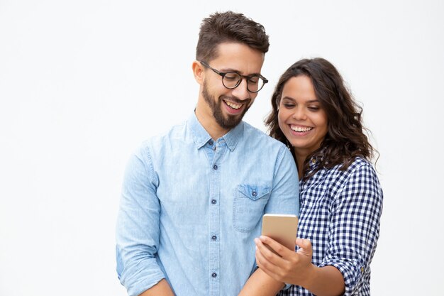 Улыбающаяся молодая пара с помощью смартфона