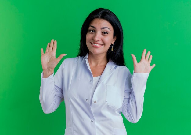 Smiling young female doctor wearing medical robe looking showing ten with hands 