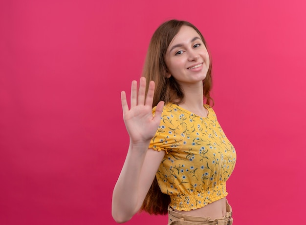 Foto gratuita ragazza sorridente che fa ciao gesto sulla parete rosa isolata con lo spazio della copia