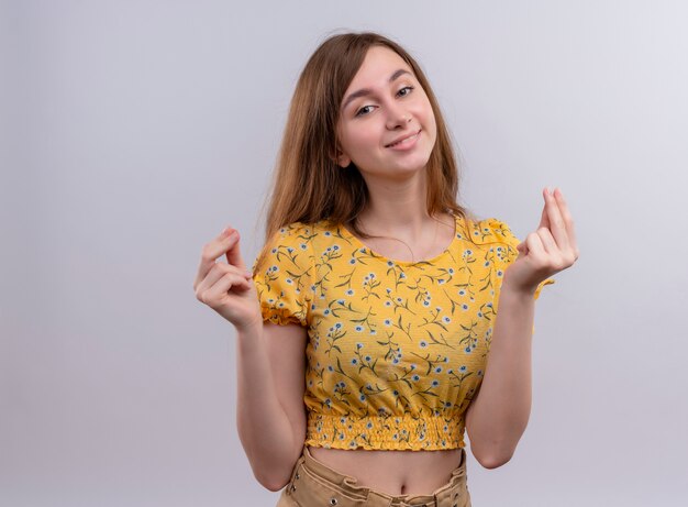 Smiling young girl doing money gesture on isolated white wall with copy space