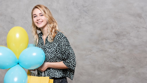 Улыбающаяся молодая девушка держит воздушные шары