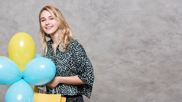 Smiling young girl holding balloons