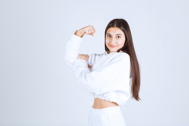 smiling young girl model showing her biceps.