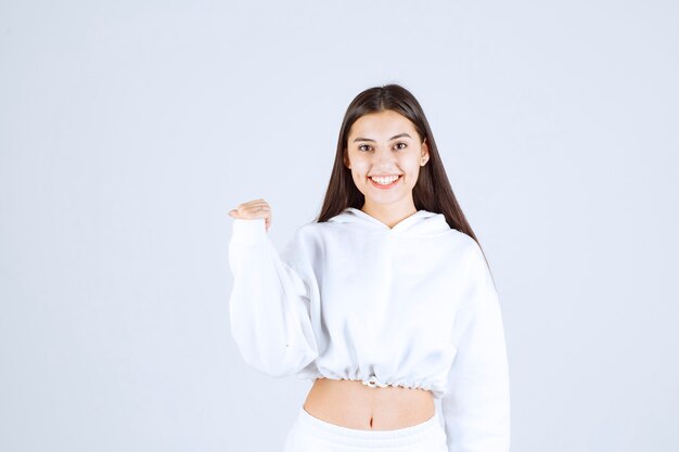 smiling young girl model standing and showing away.