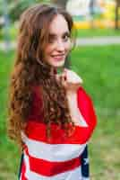 Free photo smiling young girl with american flag in nature