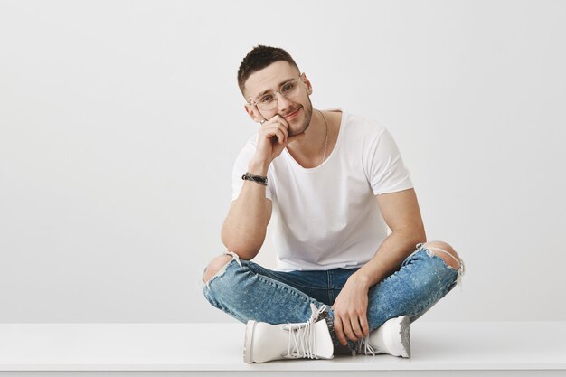 Smiling young guy with glasses posing