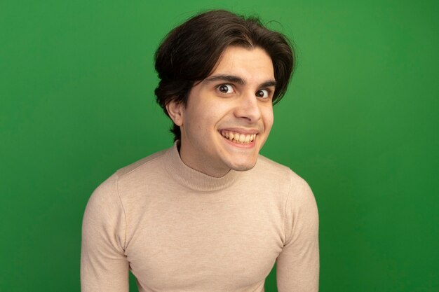 Free photo smiling young handsome guy isolated on green wall