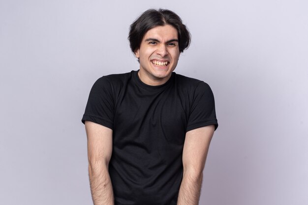 Smiling young handsome guy wearing black t-shirt isolated on white wall