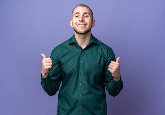 Smiling young handsome guy wearing green shirt showing thumbs up 