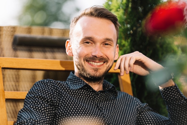 Foto gratuita giovane uomo bello sorridente che guarda l'obbiettivo