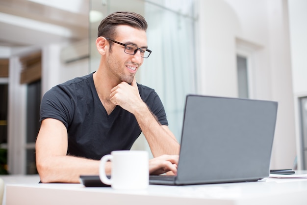 Smiling Young Handsome Man Working on Laptop