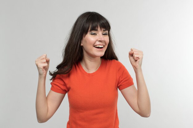 smiling young lady in designed t-shirt in good mood with long hair on white