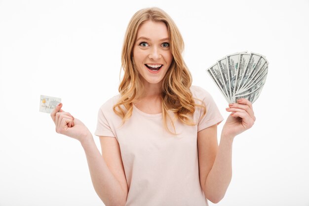 Smiling young lady holding money and credit card.