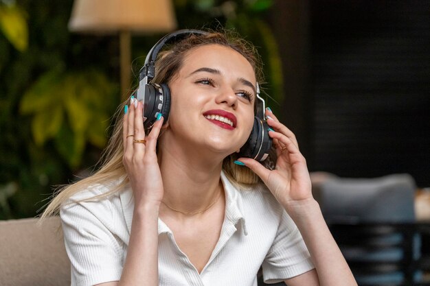 Smiling young lady wearing headphones at the restaurant