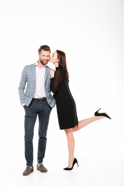 Smiling young loving couple standing isolated