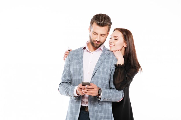 Smiling young loving couple standing isolated