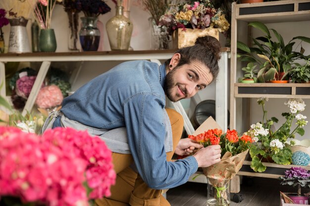꽃다발에 꽃을 정렬 웃는 젊은 남성 꽃집