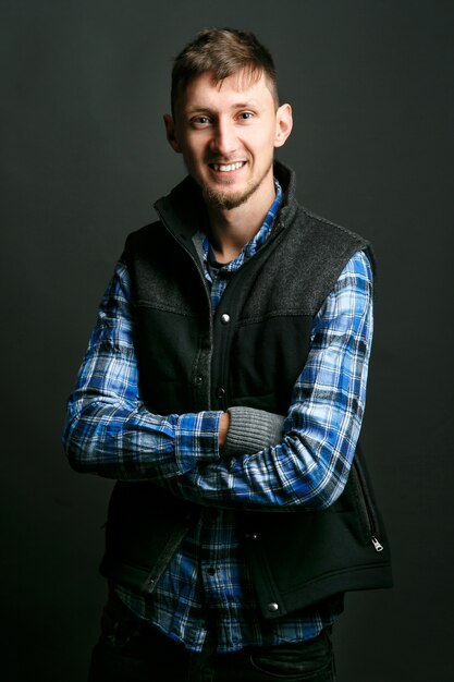 Smiling young man in blue shirt and dark waistcoat 