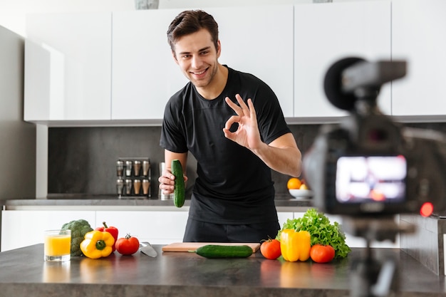 Smiling young man filming his video blog episode