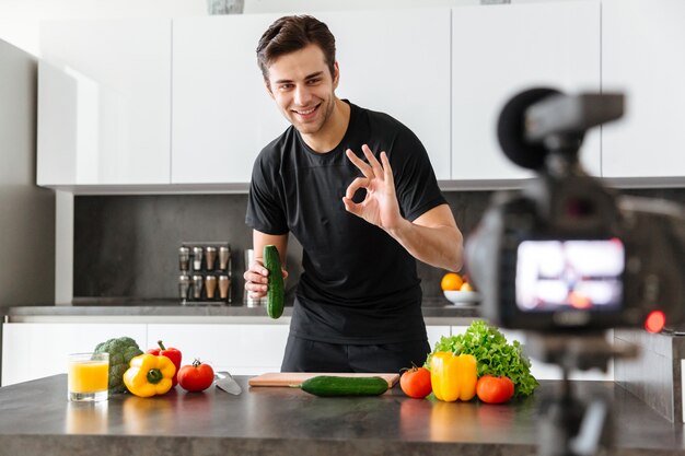 Smiling young man filming his video blog episode