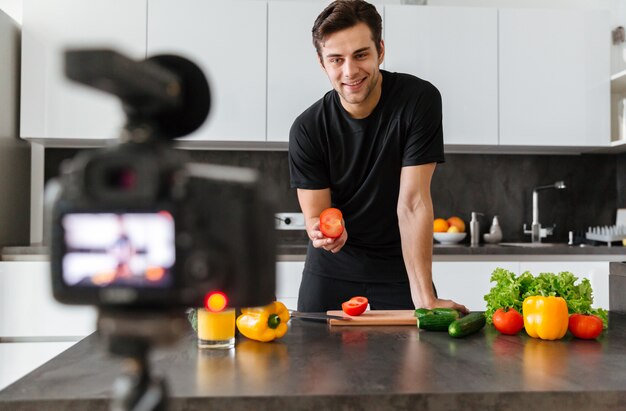 Smiling young man filming his video blog episode