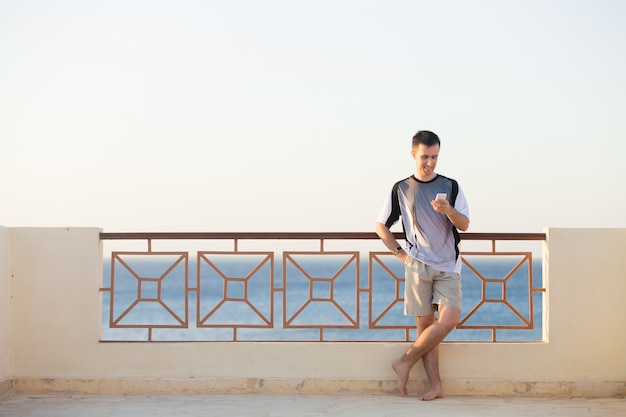 Smiling young man holding cellphone