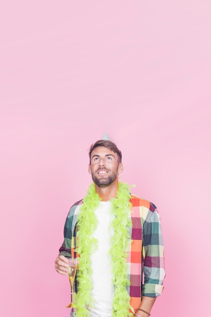 Smiling young man holding champagne flute looking up