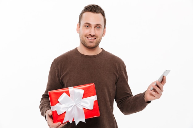 Smiling young man holding gift box surprise.