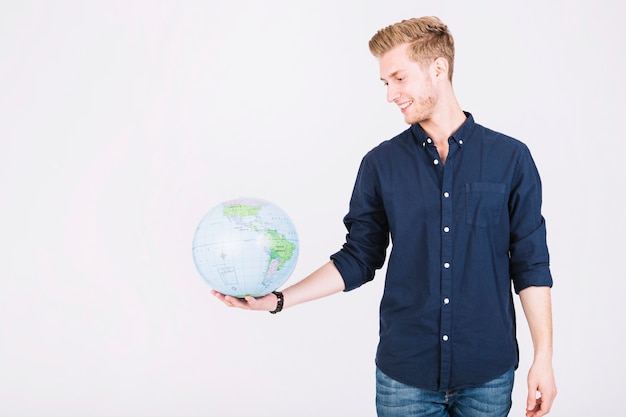 Smiling young man looking at globe