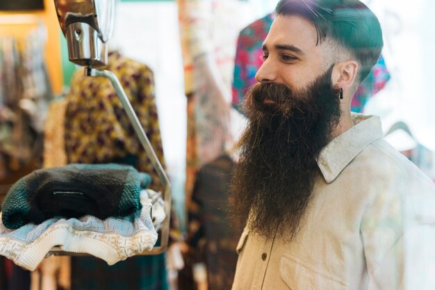 Smiling young man looking at scales in the clothing shop