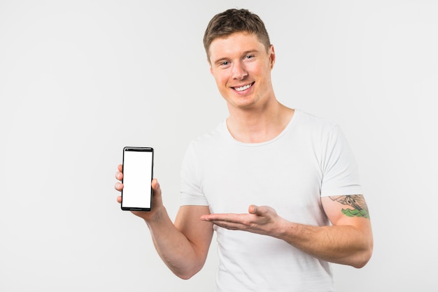 Free photo smiling young man presenting this new smart phone with white display screen