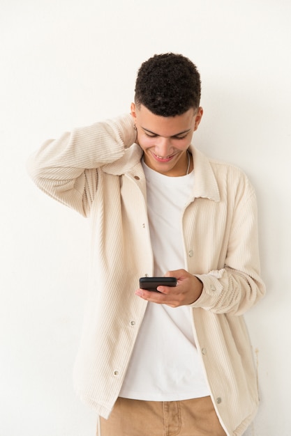 Smiling young man using mobile phone