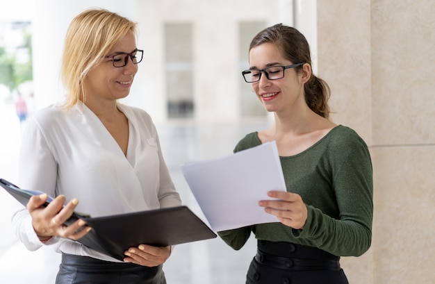 Giovane manager sorridente che dà rapporto cartaceo