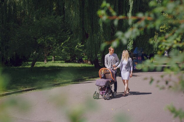 Smiling young parents walking with their baby