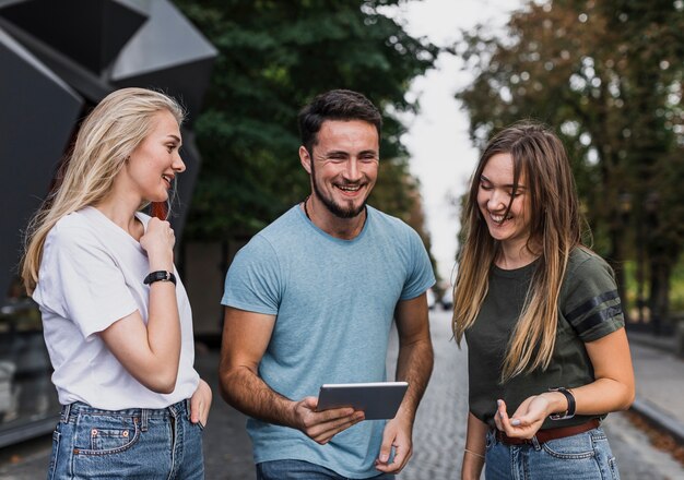 Foto gratuita giovani sorridenti che guardano in una compressa