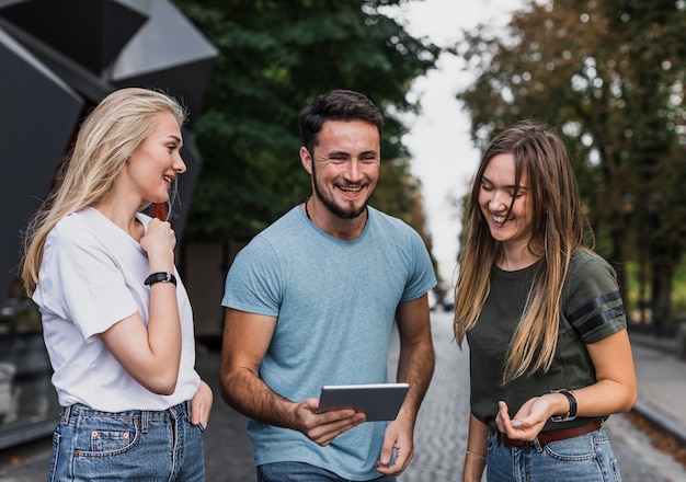 Smiling young people looking in a tablet