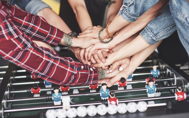 Smiling young people playing table football while on vacation