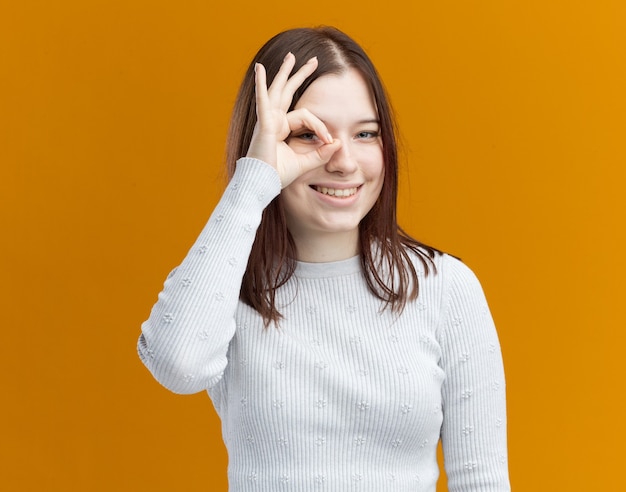 Smiling young pretty girl doing look gesture 