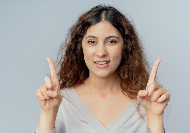 Free photo smiling young pretty office worker points at different sides isolated on white