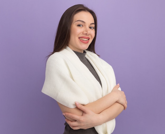 Smiling young pretty woman standing with closed posture in profile view